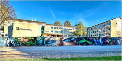 Graffitikünstler gestaltet Bauzaun am Abdinghof